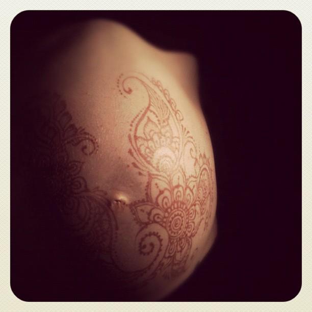 Pregnant belly with a henna tattoo.