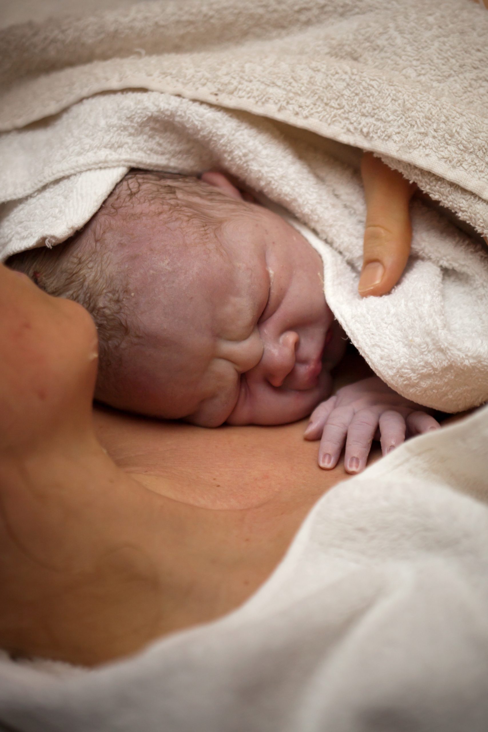 Childbirth Mother holding a newborn baby skin-to-skin.