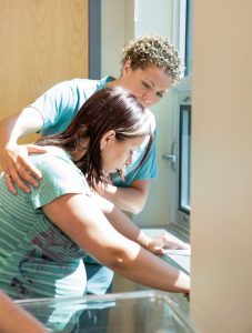 Friendly female nurse comforting worried pregnant woman who is having a contraction