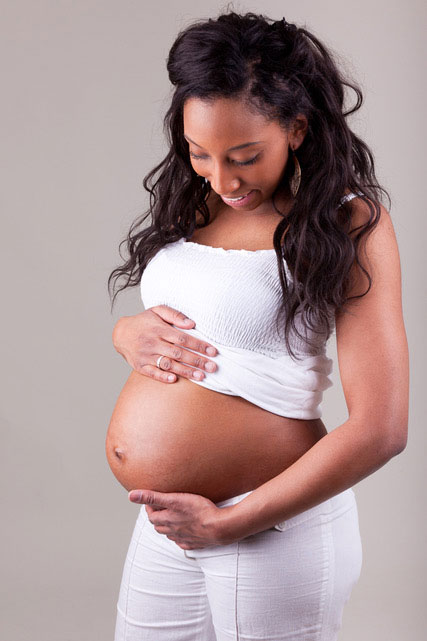Pregnant woman holding her stomach.